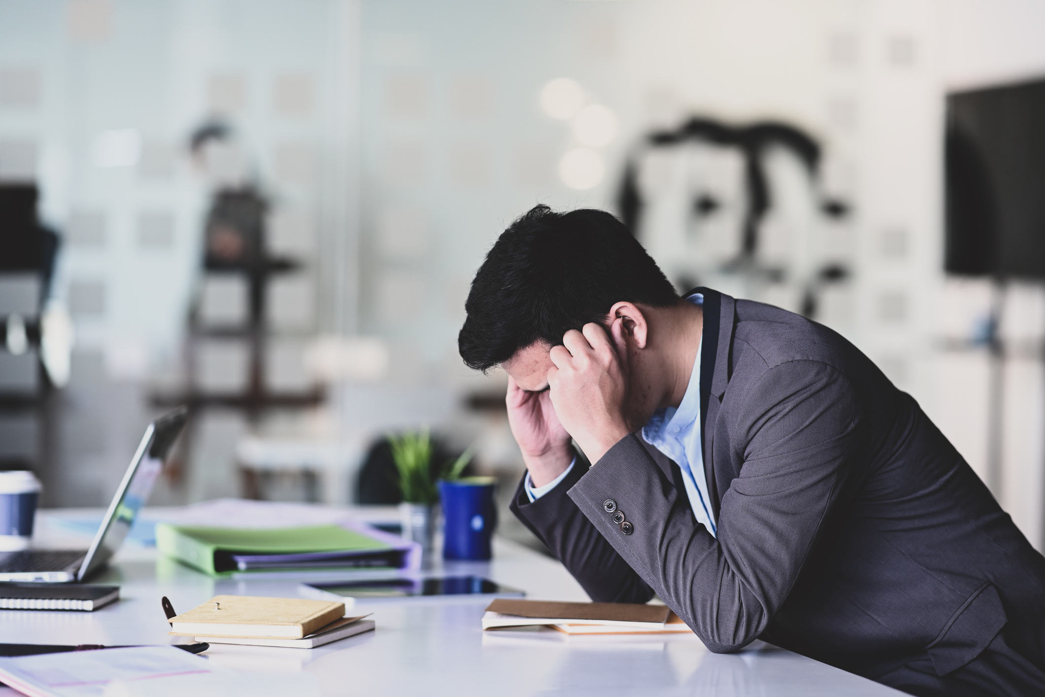 Stressful young businessman holding his heads and feeling stressed about work.