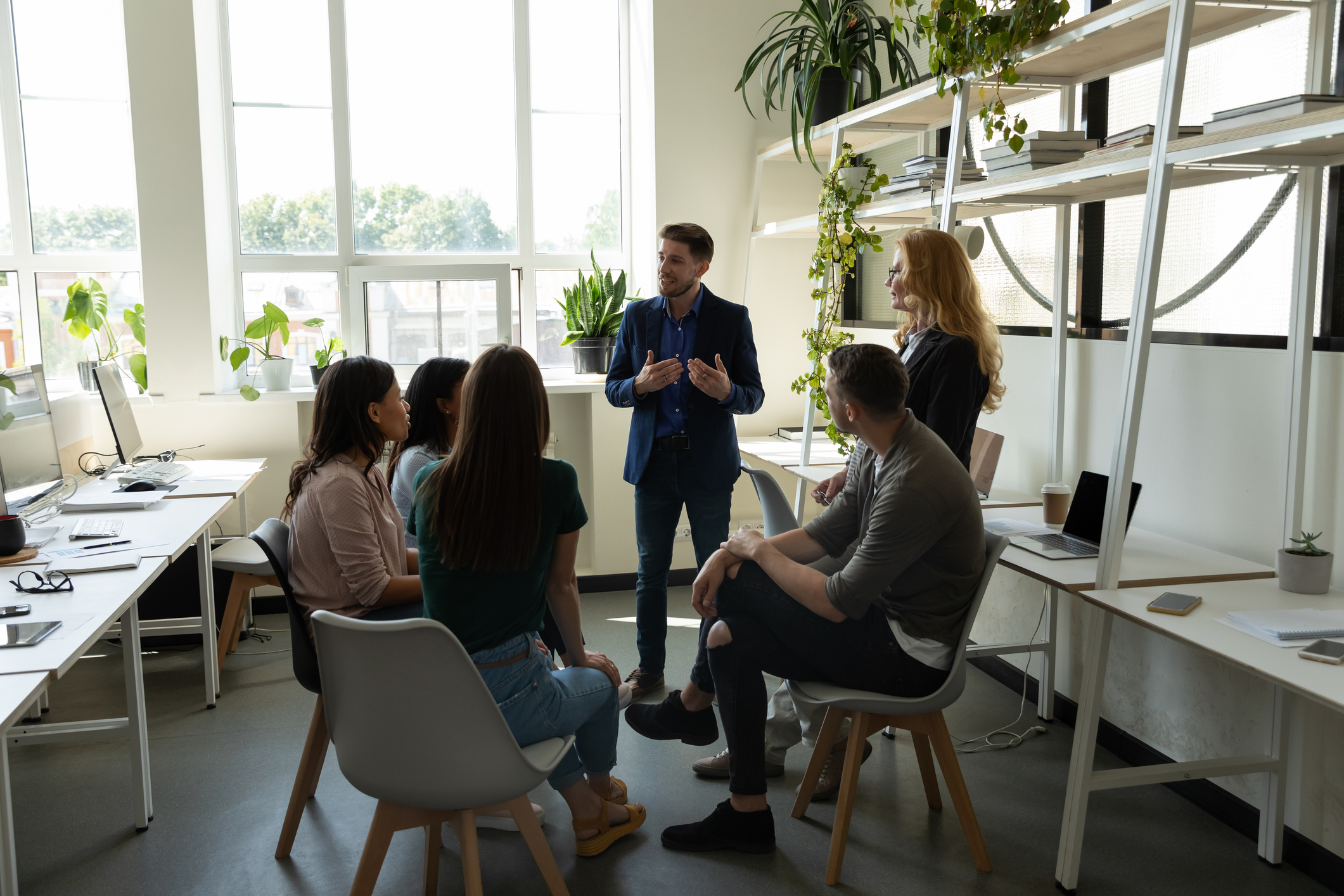 Diverse student group and professor listening to classmate on seminar