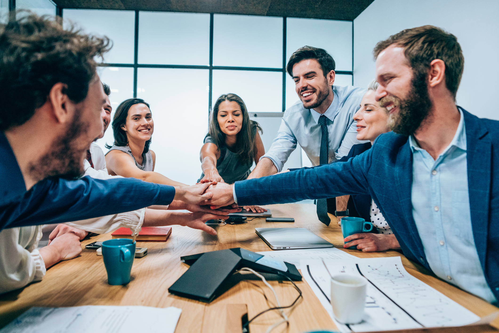 Business people stacking hands in conference room