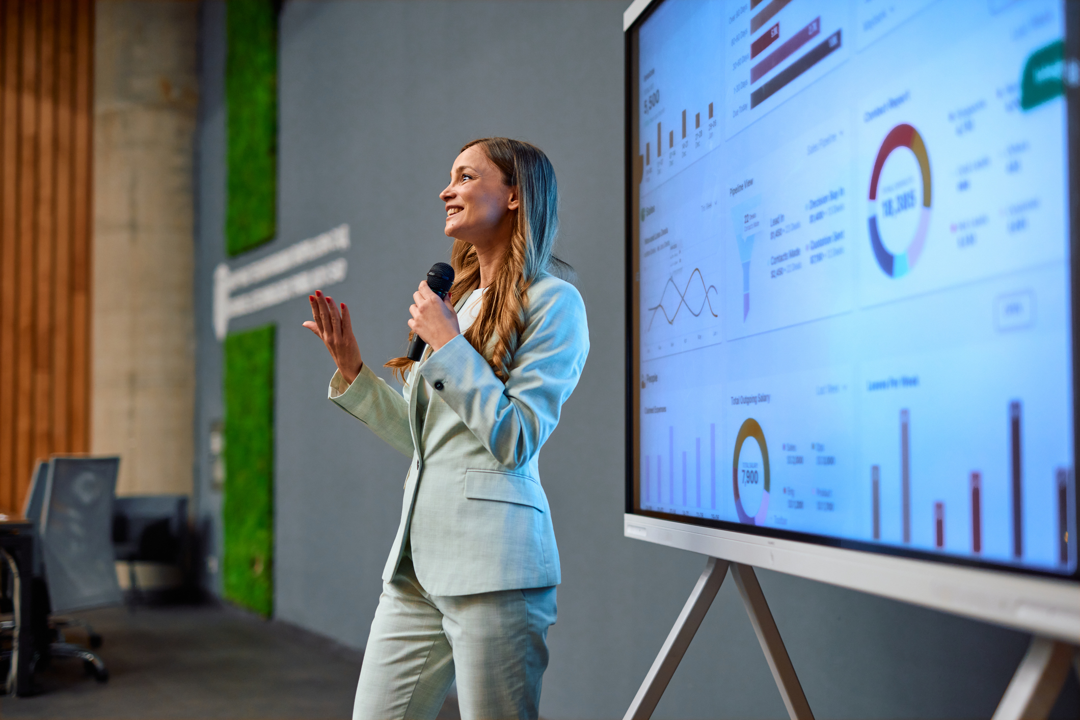 Businesswoman presenting marketing data using interactive whiteboard during a conference