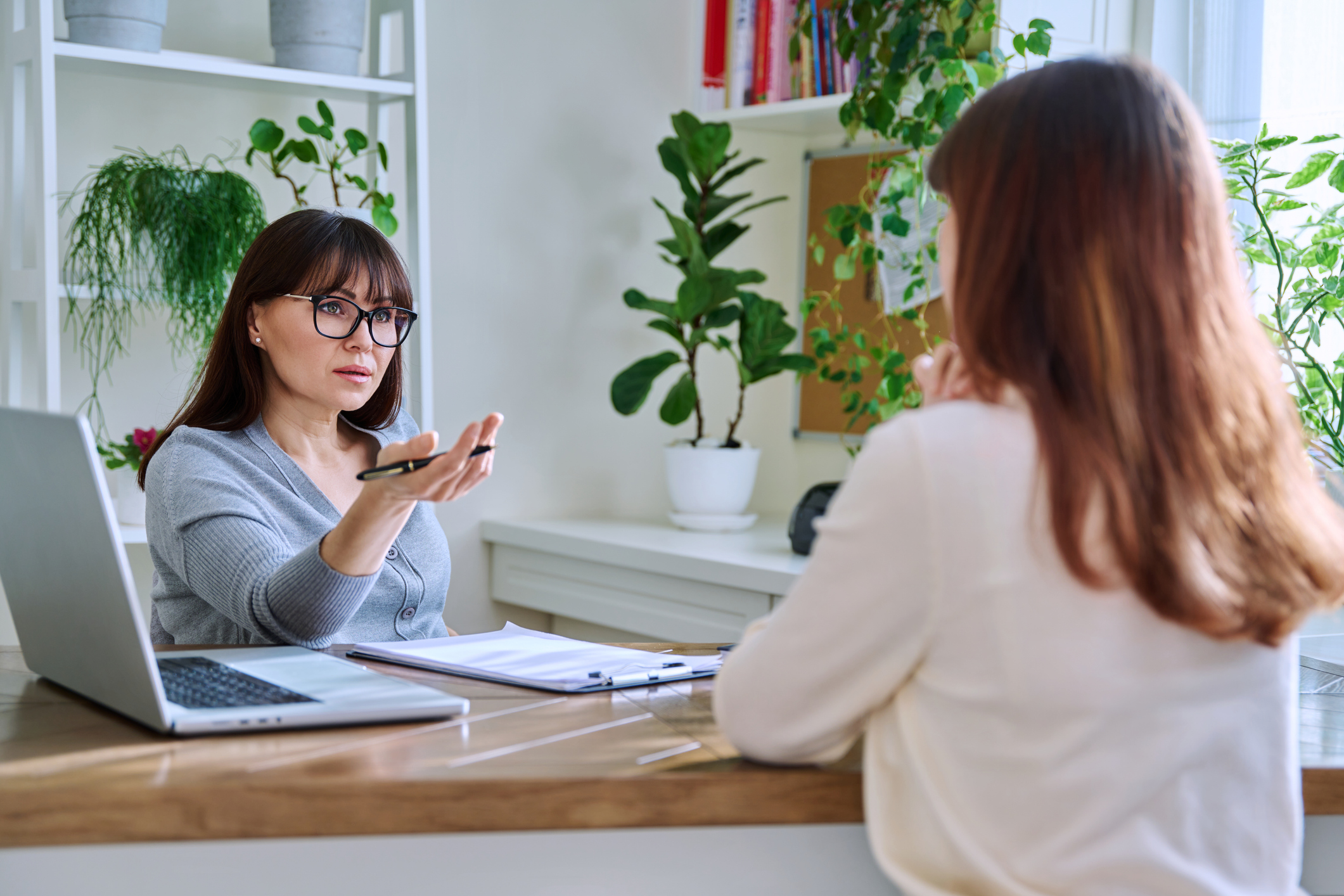 Middle-aged female psychologist, counselor working with young woman patient