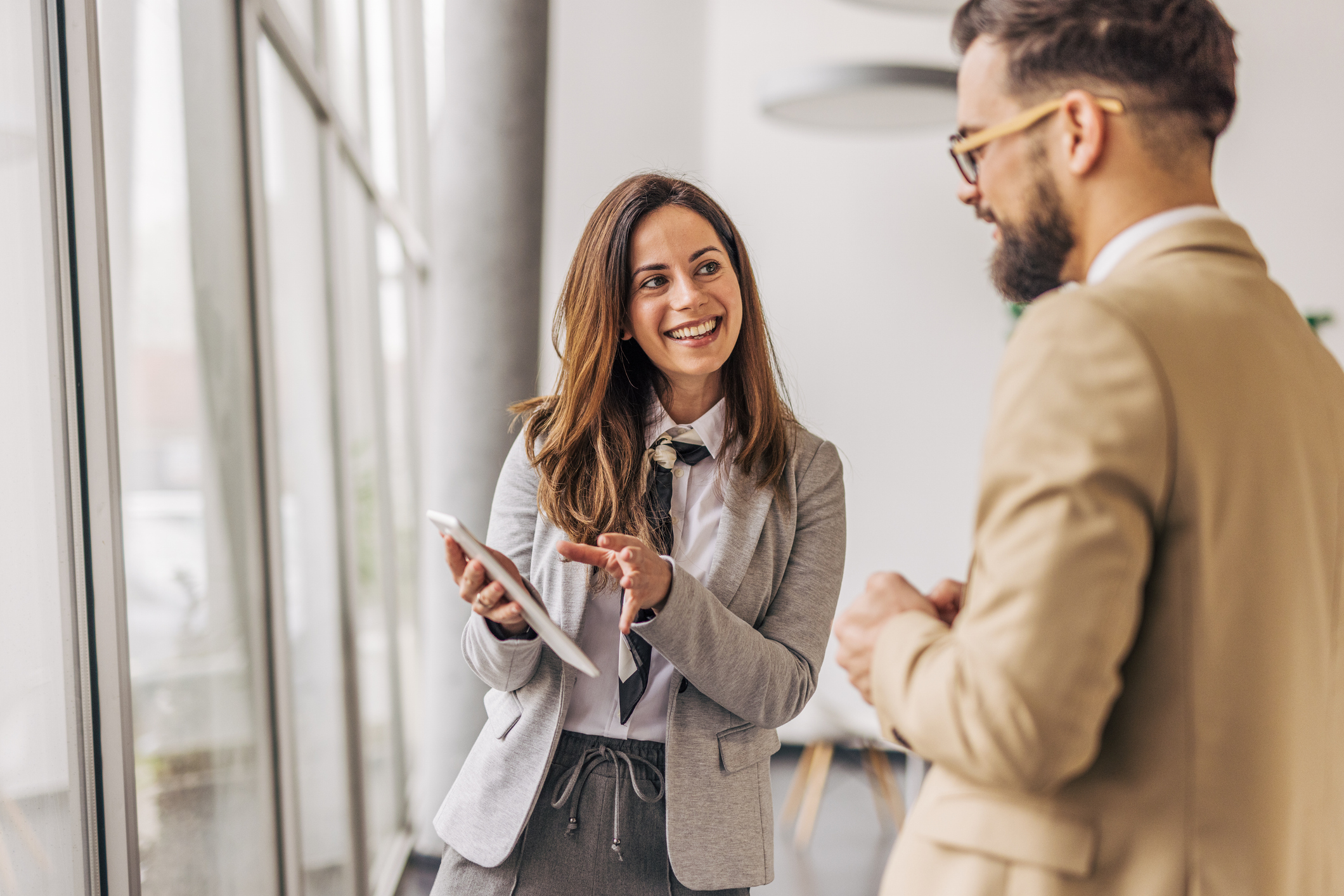 Businesswoman showing digital tablet to male colleague in office
