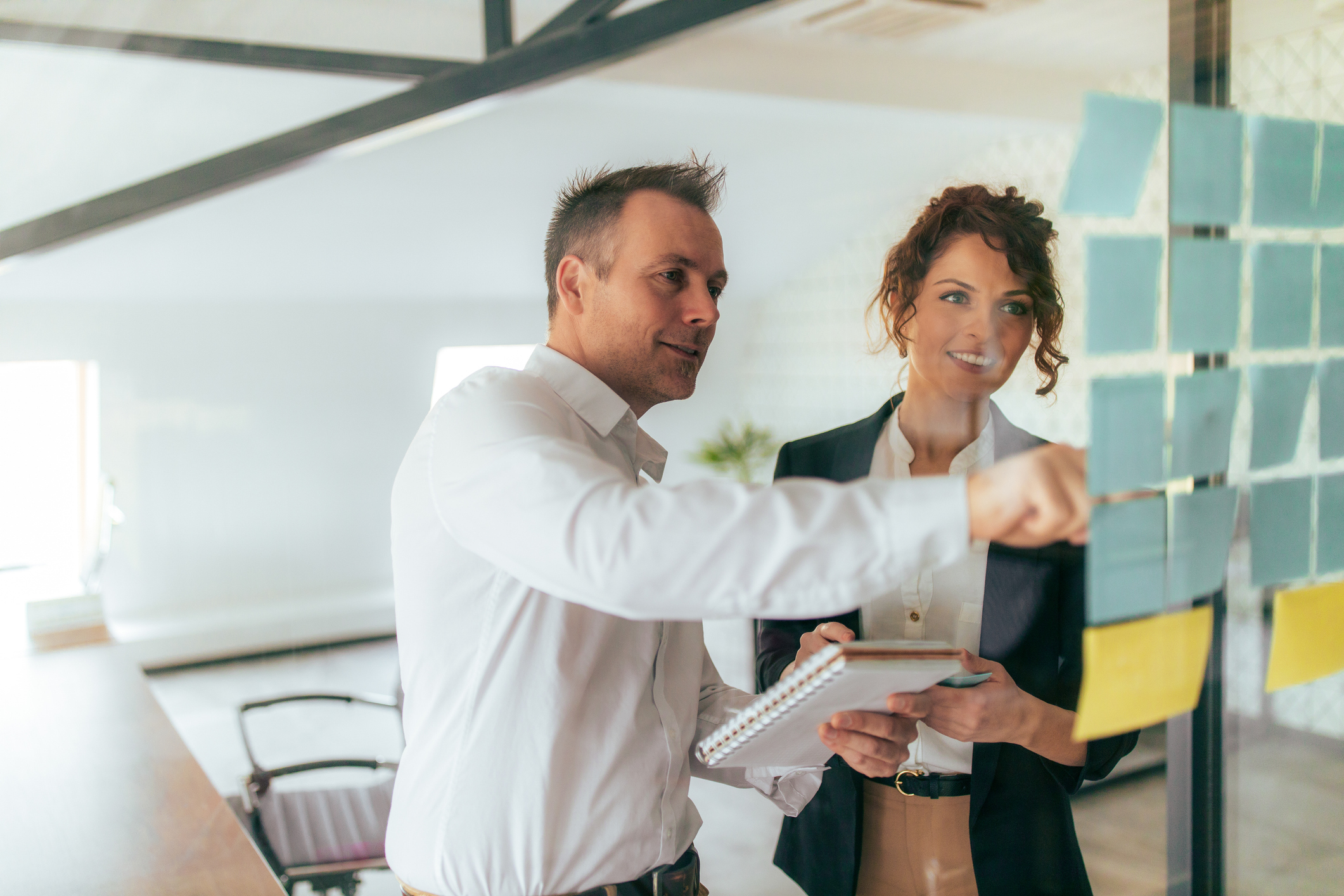 Positive colleagues working with post it notes, portrait.