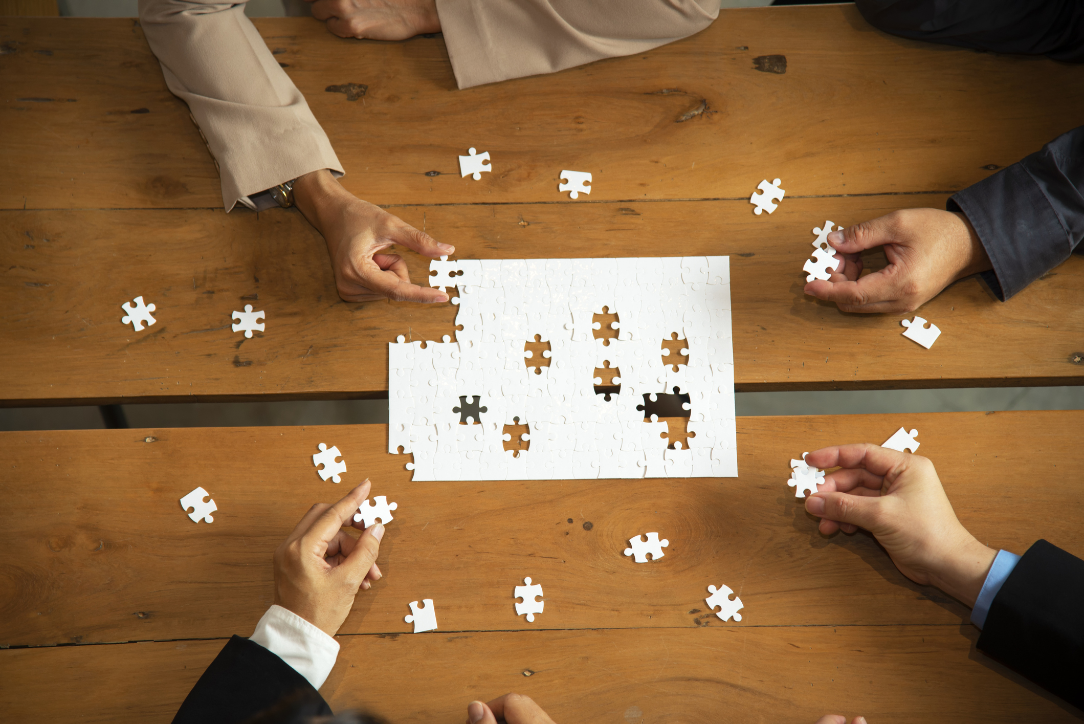 Hands of business people holding jigsaw, thinking about the successful good fit for concept of corporate recruitment, difference or cooperation strategy.Business Concept