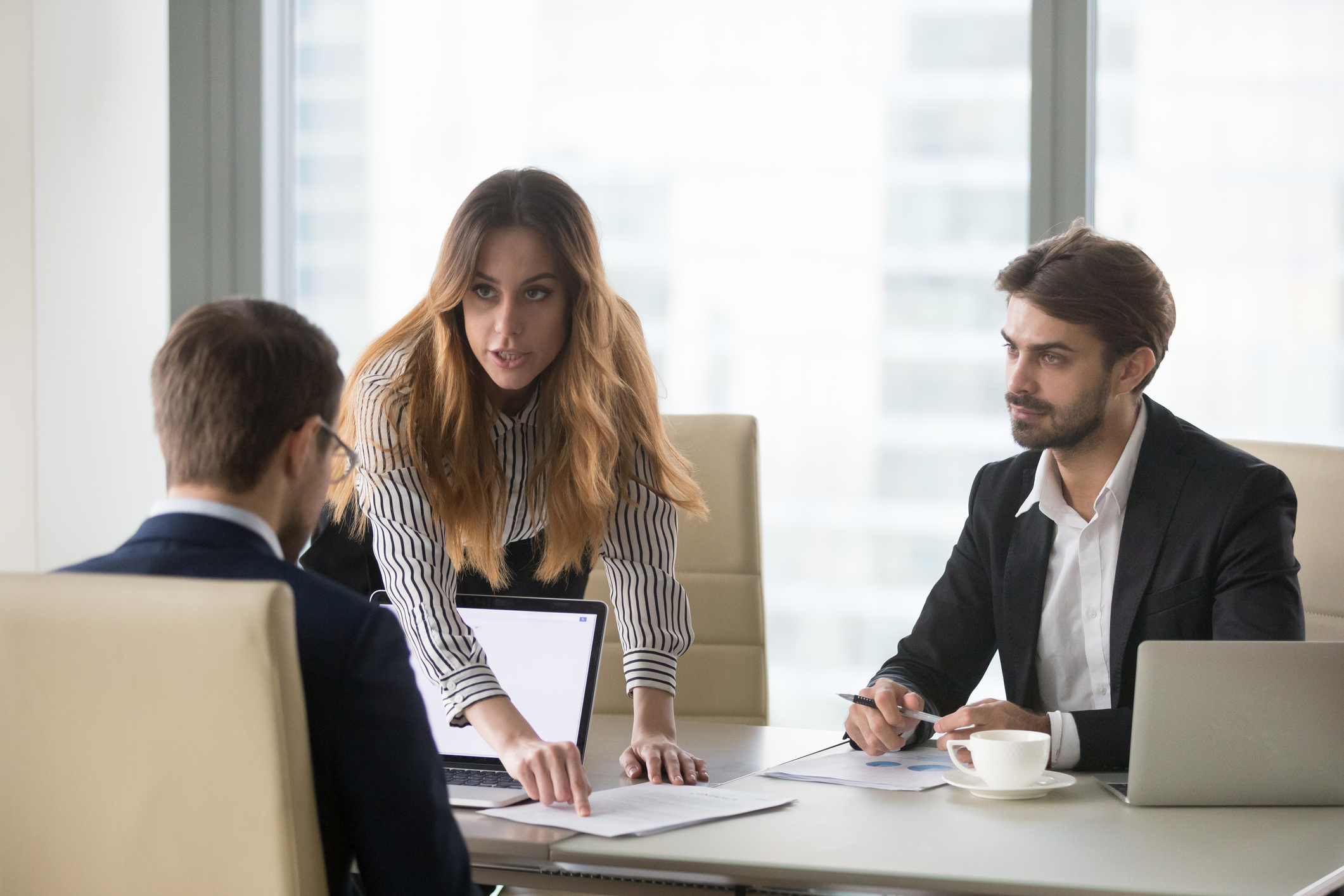 Mad woman showing document mistake to male partner during meeting