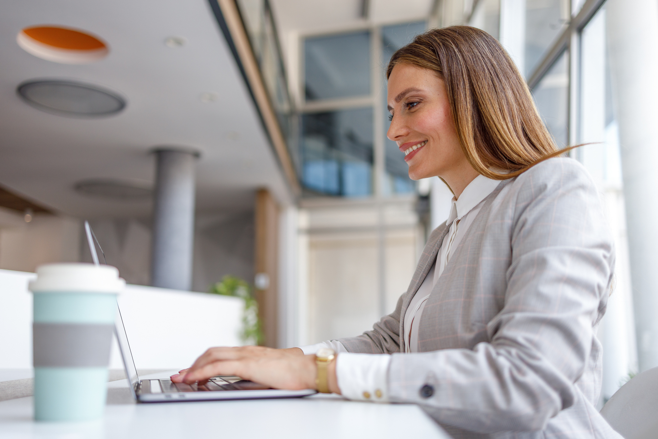 Professional woman working on laptop in modern office